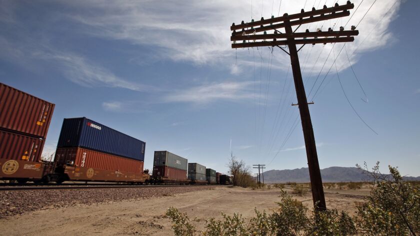Container cars cross the Mojave Desert on tracks that Cadiz Inc. hopes to use for a water pipeline -- but the Trump administration's support has been a mixed blessing.