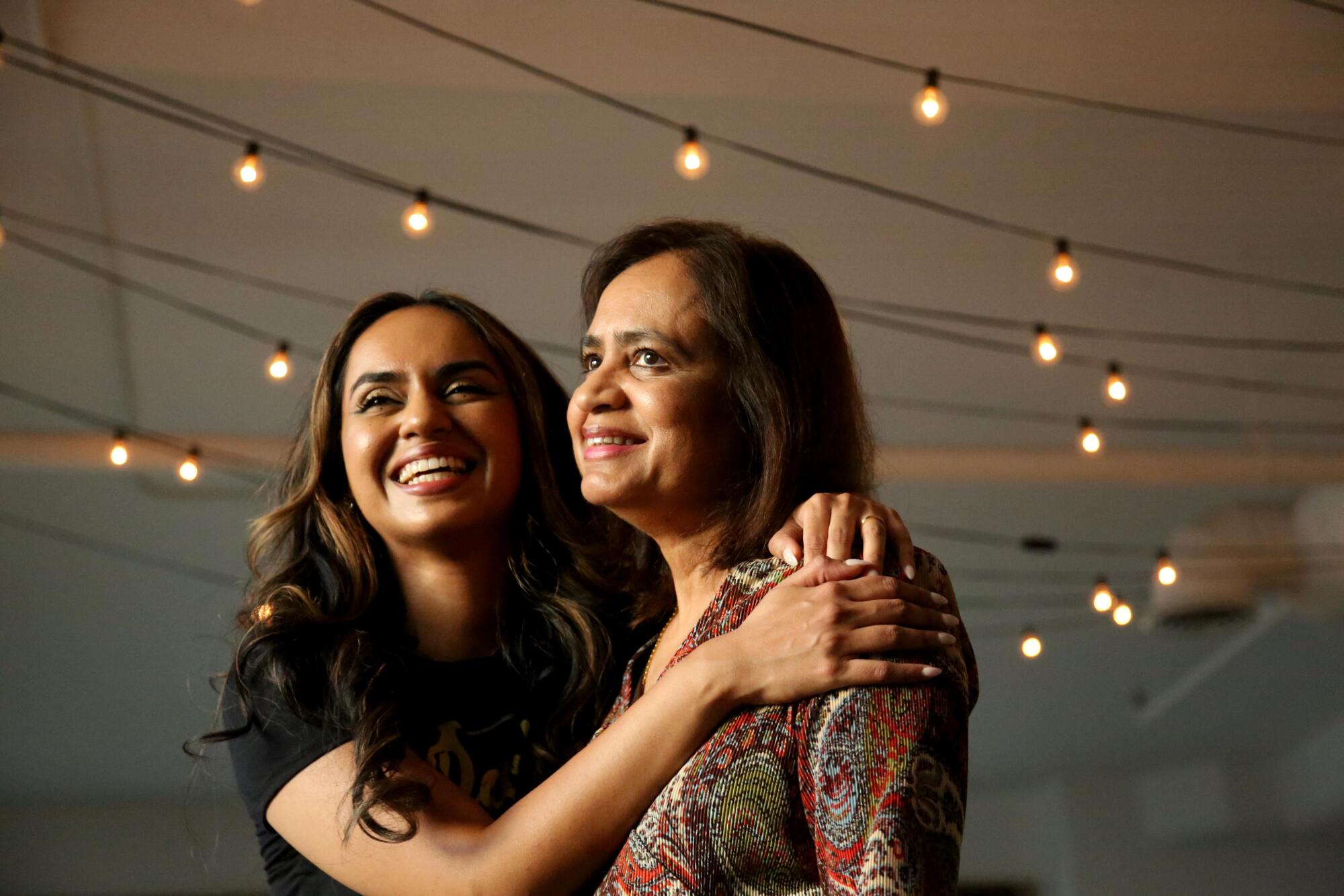 A young woman smiles and embraces her mother