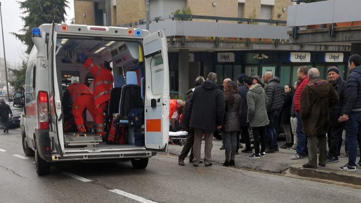 Paramedics treat a man wounded by gunfire in Macerata, Italy, on Feb. 3, 2018.
