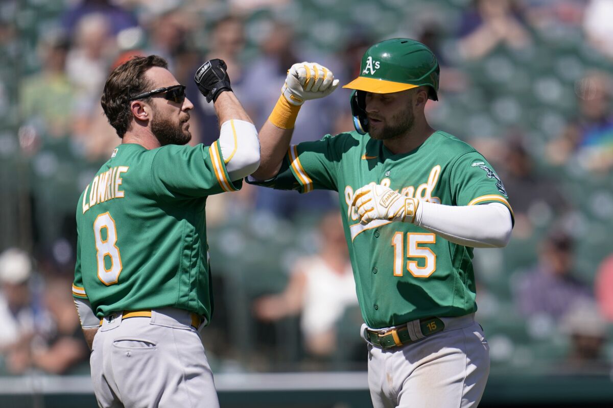 Oakland Athletics' Seth Brown (15) celebrates his two-run home run with Jed Lowrie (8) against the Detroit Tigers in the eighth inning of a baseball game in Detroit, Thursday, May 12, 2022. (AP Photo/Paul Sancya)