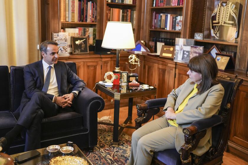 Greek President Katerina Sakellaropoulou, right, meets Greece's center-right Prime Minister Kyriakos Mitsotakis to hand the mandate trying to form a coalition government, which he is expected to return, at the Presidential Palace in Athens, Greece, Monday, May 22, 2023. Despite inflicting the most crushing defeat in half a century on the opposition, Mitsotakis is expected to seek a second national election within weeks, as he lacks the majority in Parliament to govern alone. (AP Photo/Petros Giannakouris)