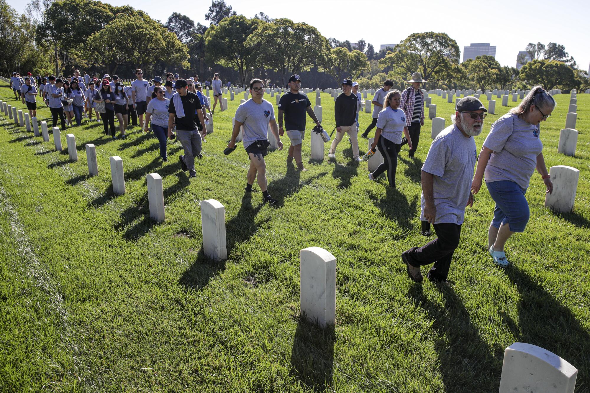 Volunteers  in Los Angeles National Cemetery to clean veterans' headstones.
