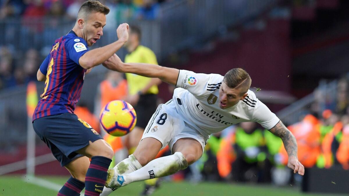 Barcelona midfielder Arthur, left, battles Real Madrid midfielder Toni Kroos for possession of the ball during a La Liga game on Oct. 28.