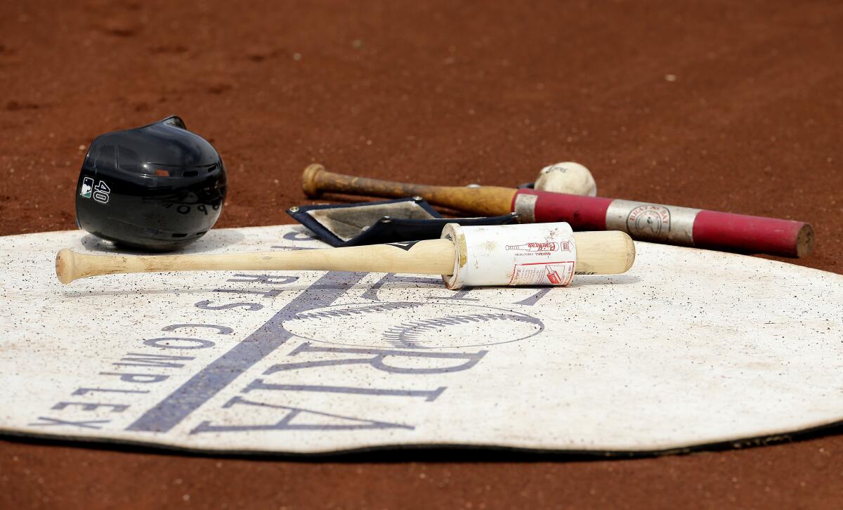 Baseball equipment sits in the on-deck circle.