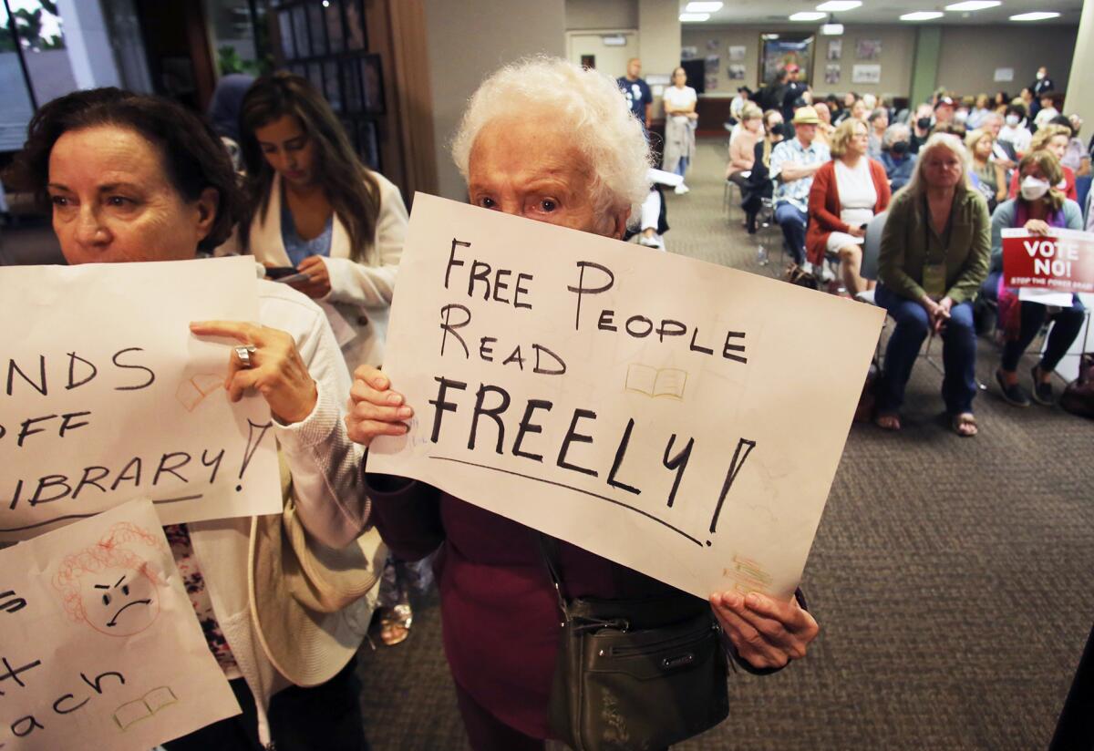 People protest a proposal to screen children's books at the H.B. City Council meeting. 