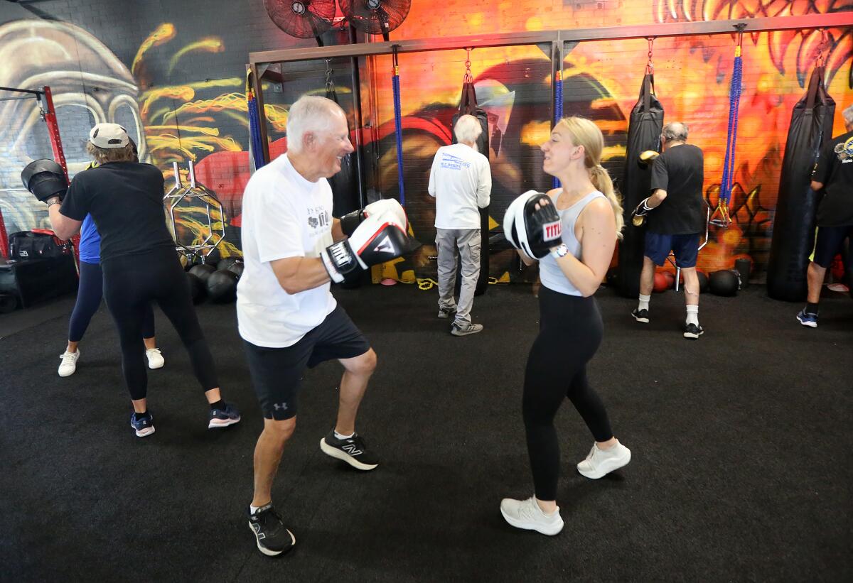 Client Mike Fulmis shares a laugh with speech pathologist Rene Lavelle, left, during a non-contact boxing workout.