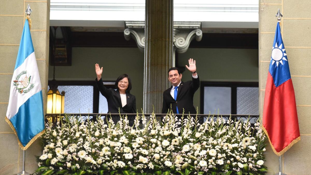 Taiwan's President Tsai Ing-wen and Guatemalan President Jimmy Morales wave from a balcony at the Culture Palace in Guatemala City on Jan. 11, 2017.