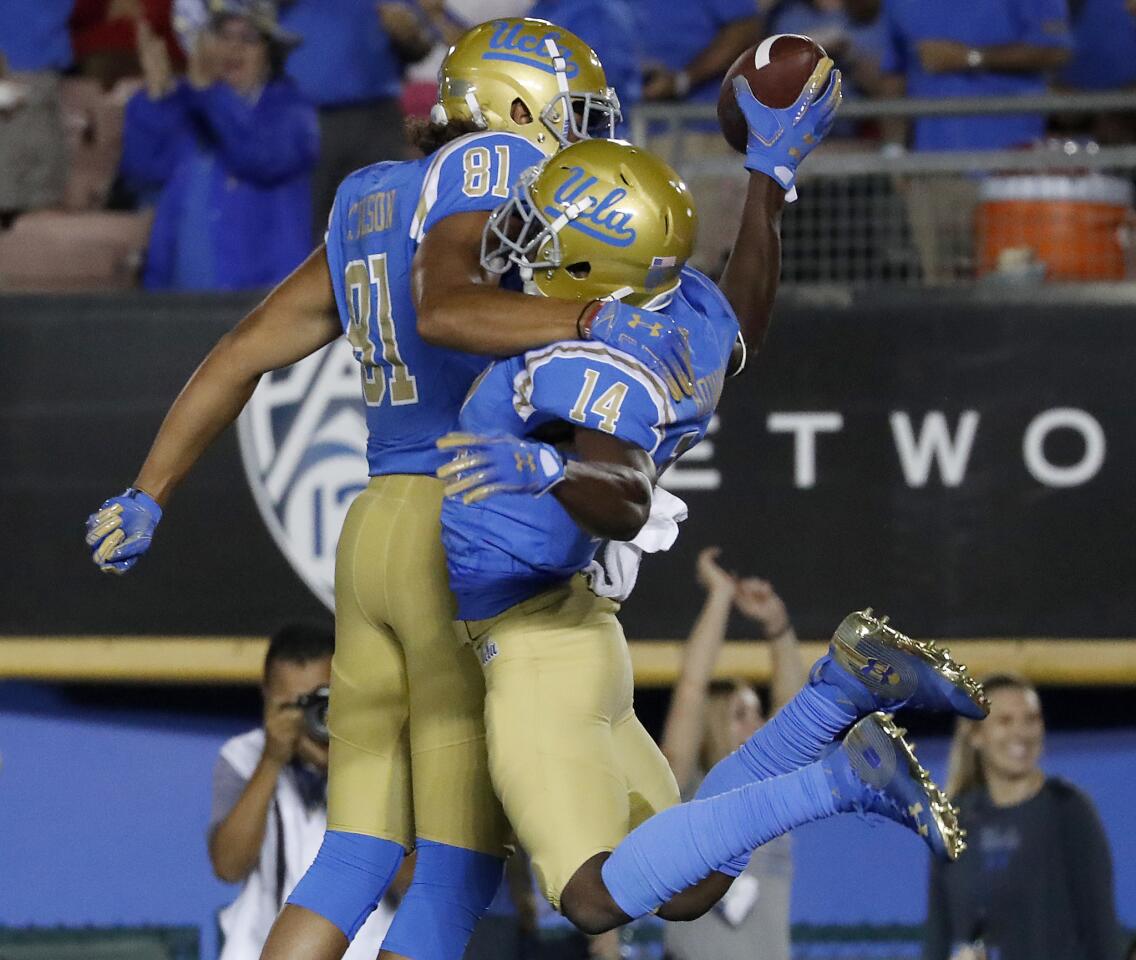 UCLA wide receiver Theo Howard, left, celebrates with teammate Caleb Wilson after scoring a touchdown against Fresno State in the second quarter on Saturday at the Rose Bowl.