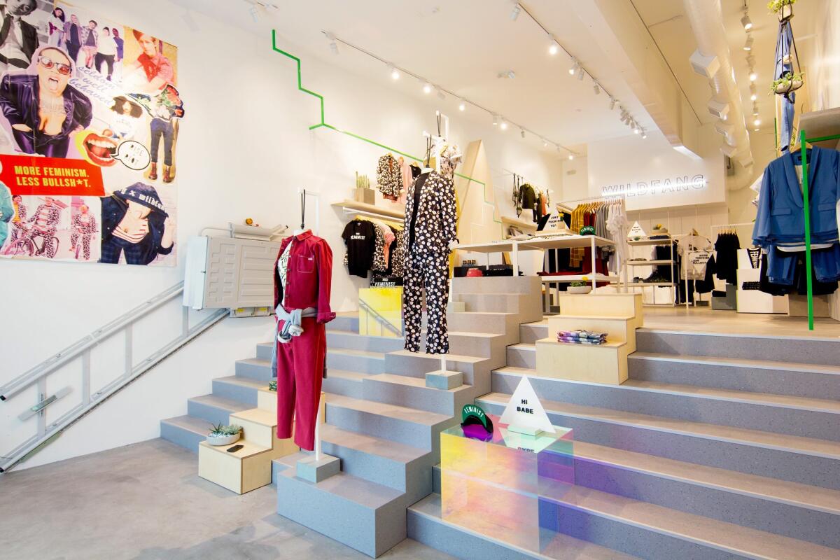 The interior of Wildfang features mannequins standing on steps up to a second level 