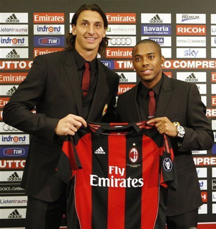 AC Milan newly signed soccer forwards Zlatan Ibrahimovic, of Sweden, left, and Robinho, of Brazil, show a team jersey during the official presentation in downtown Milan, Italy, Thursday, Sept 9, 2010. (AP Photo/Antonio Calanni)