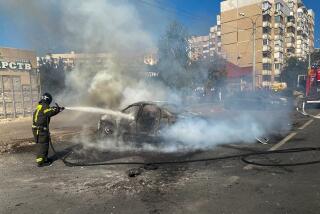 This photo released by Belgorod regional governor Vyacheslav Gladkov's Telegram channel on Sunday, Sept. 1, 2024, firefighters extinguish a burning car in the courtyard of an apartment building after a missile attack by the Armed Forces of Ukraine on the city of Belgorod and the Belgorod region of Russia. (Belgorod Region Governor Vyacheslav Gladkov Telegram channel via AP)