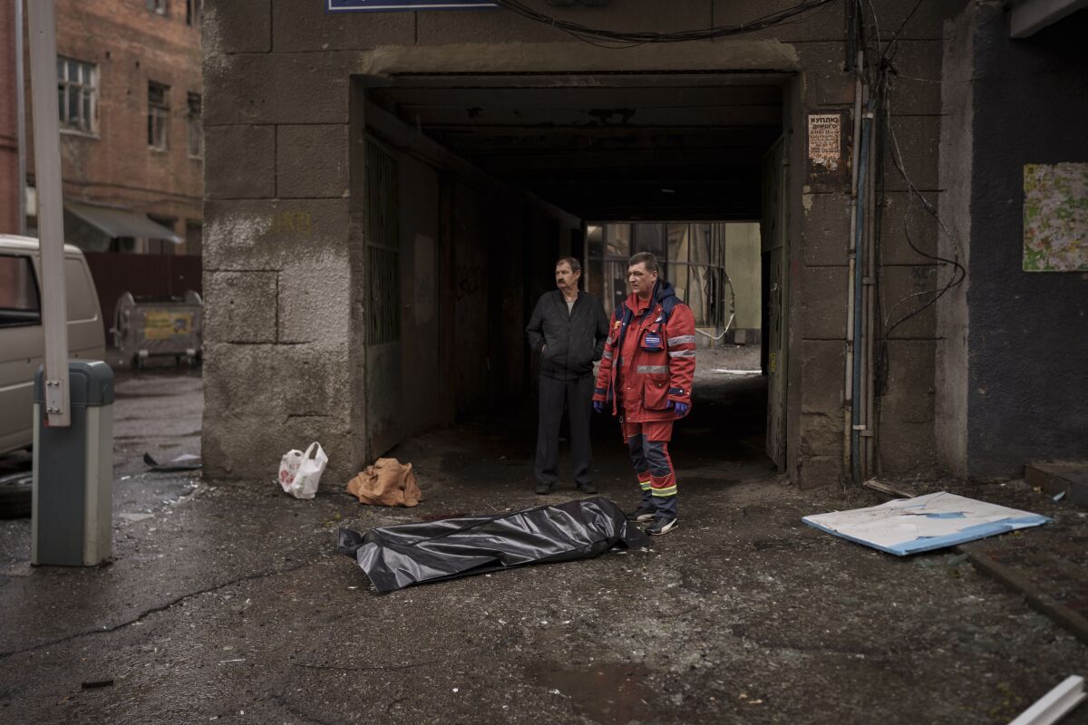 The body of a woman killed a Russian bombardment lies on a sidewalk in downtown Kharkiv, Ukraine, Sunday, April 17, 2022. (AP Photo/Felipe Dana)