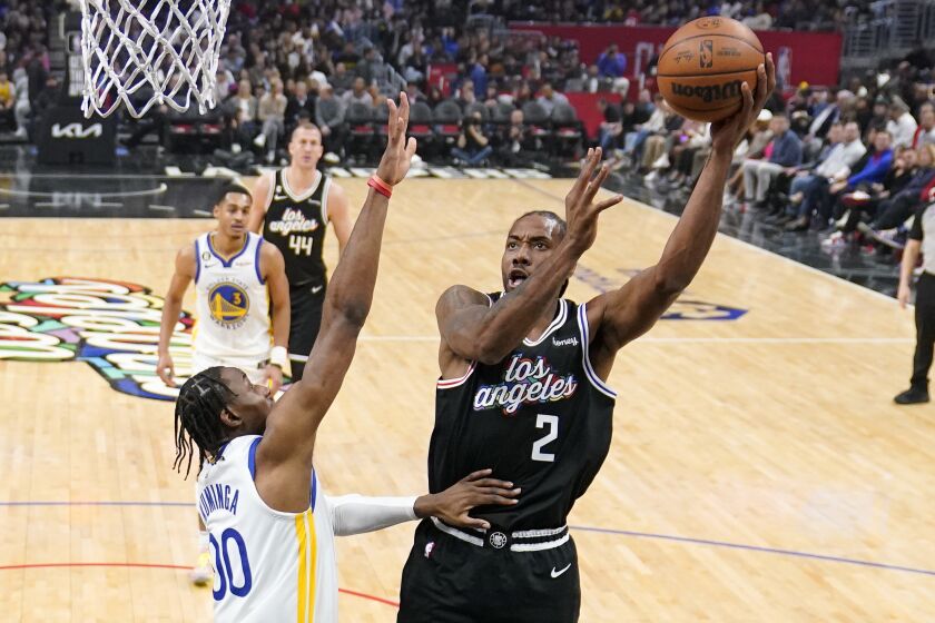 Los Angeles Clippers forward Kawhi Leonard, right, shoots as Golden State Warriors forward Jonathan Kuminga defends during the first half of an NBA basketball game Tuesday, Feb. 14, 2023, in Los Angeles. (AP Photo/Mark J. Terrill)