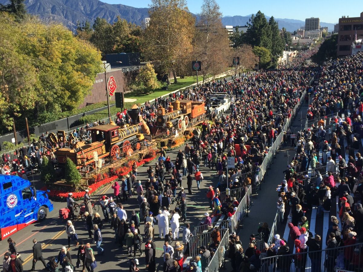 Rose Parade attendees stream past a float that broke down Tuesday.