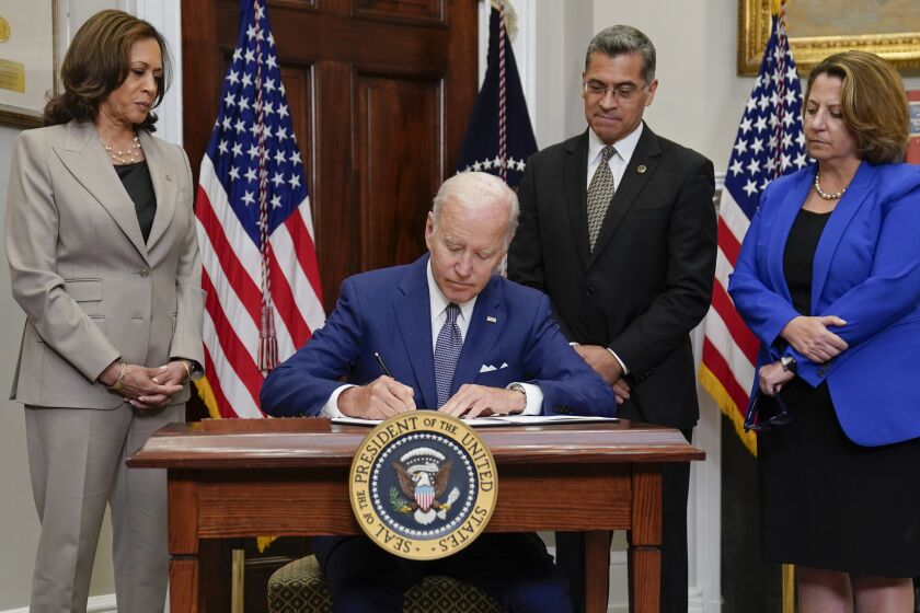President Joe Biden signs an executive order on abortion access during an event in the Roosevelt Room of the White House, Friday, July 8, 2022, in Washington. From left, Vice President Kamala Harris, Biden, Health and Human Services Secretary Xavier Becerra, and Deputy Attorney General Lisa Monaco. (AP Photo/Evan Vucci)