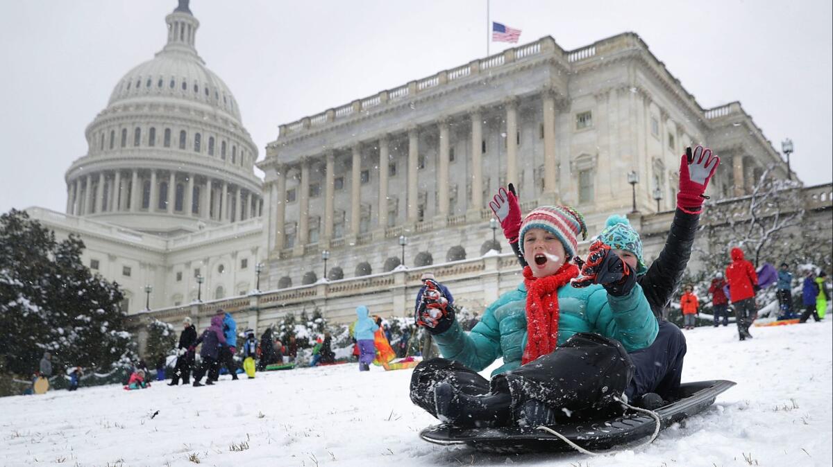 Children sled on the grounds of the U.S. Capitol.
