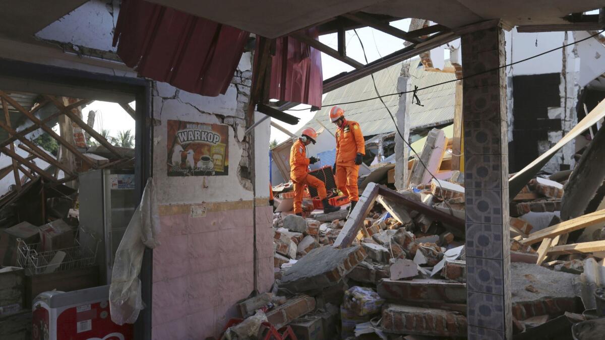 Rescue teams search for victims in the rubble Monday after an earthquake in North Lombok, Indonesia.