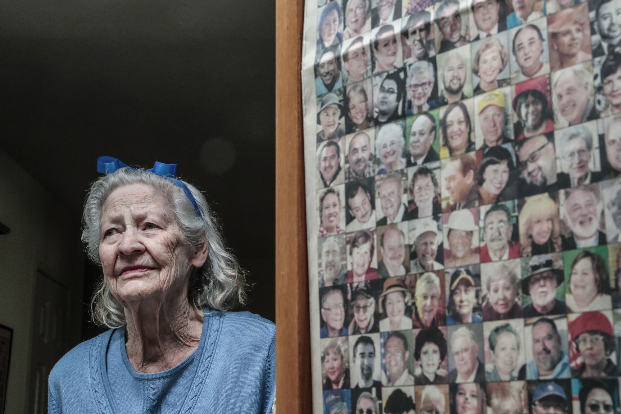 A woman stands next to a page of photos