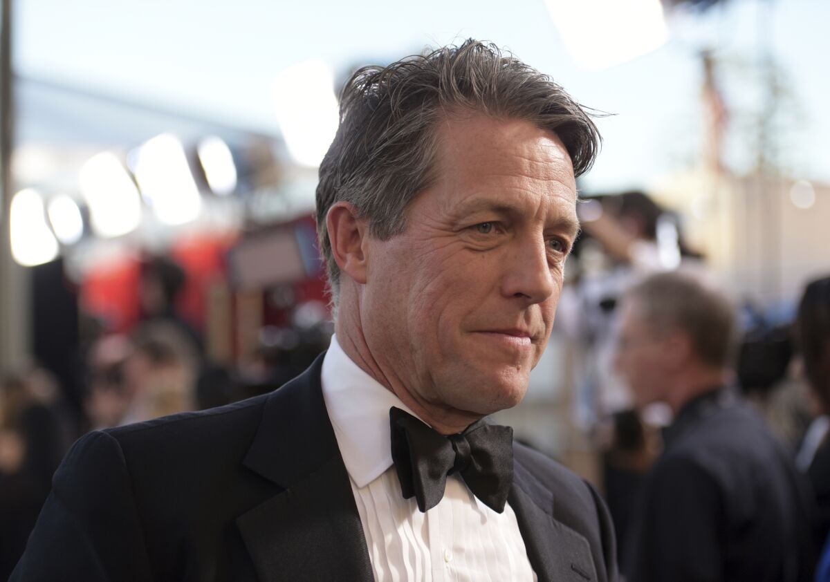FILE - Hugh Grant arrives at the 23rd annual Screen Actors Guild Awards at the Shrine Auditorium & Expo Hall in Los Angeles, Sunday Jan. 29, 2023. A London court on Friday rejected an attempt by the publisher of The Sun tabloid to throw out a lawsuit by actor Hugh Grant alleging that journalists and investigators it hired illegally snooped on him. (Photo by Richard Shotwell/Invision/AP, File)