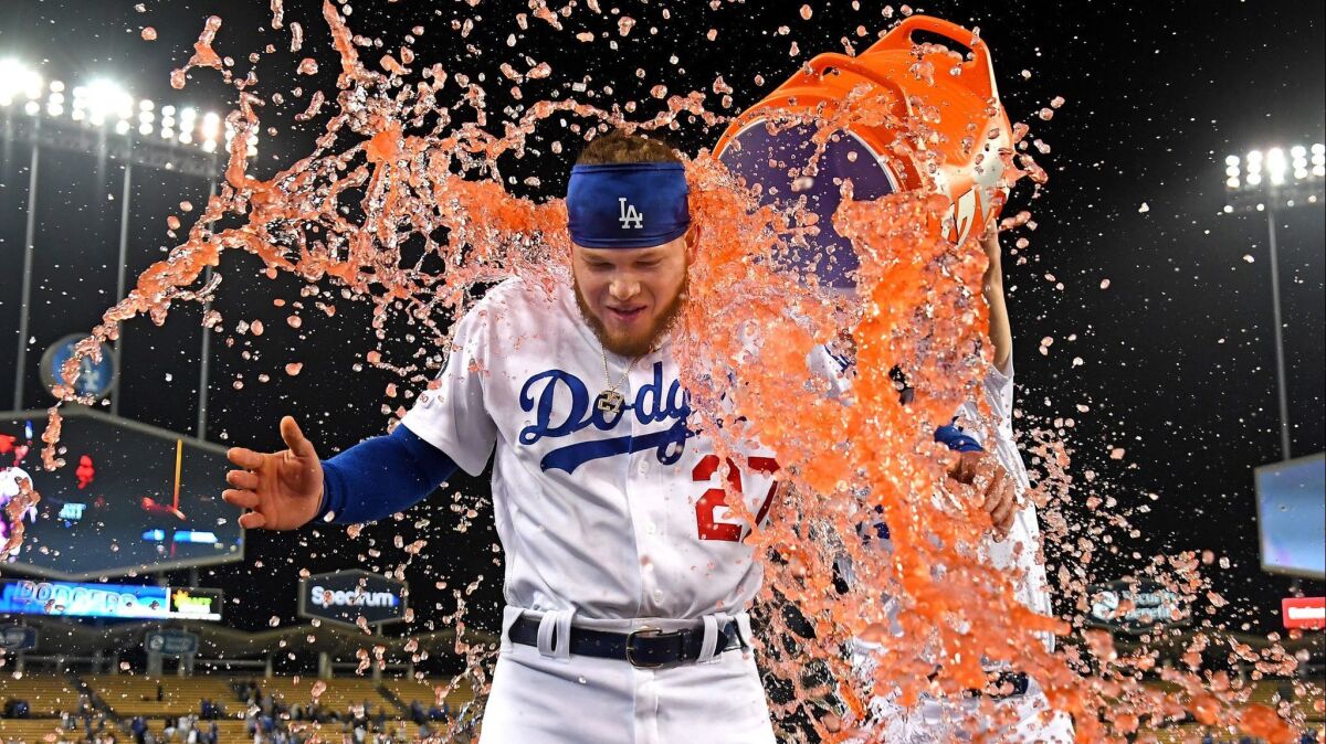 Joc Pederson unloads an ice cooler on Dodgers teammate Alex Verdugo after his sacrifice fly drove in the winning run against the New York Mets on May 29. The Dodgers are winning games and spurring prognostications about their title chances.