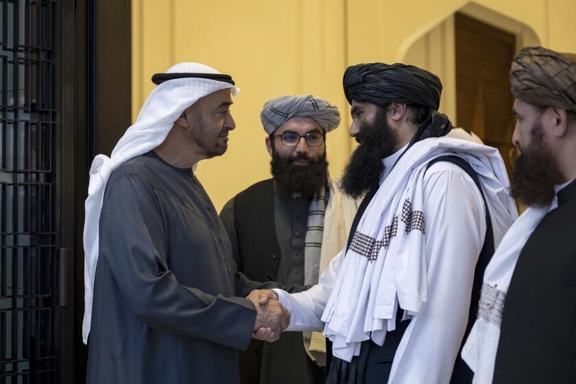 In this photograph released by the state-run WAM news agency, Emirati leader Sheikh Mohammed bin Zayed Al Nahyan, ruler of Abu Dhabi, left, shakes hands with Taliban official Sirajuddin Haqqani at Qasr Al Shati palace in Abu Dhabi, United Arab Emirates, Tuesday, June 4, 2024. The leader of the United Arab Emirates met Tuesday with an official in the Taliban government still wanted by the U.S. on an up-to $10 million bounty over his involvement in an attack that killed an American citizen and other assaults. (WAM via AP)