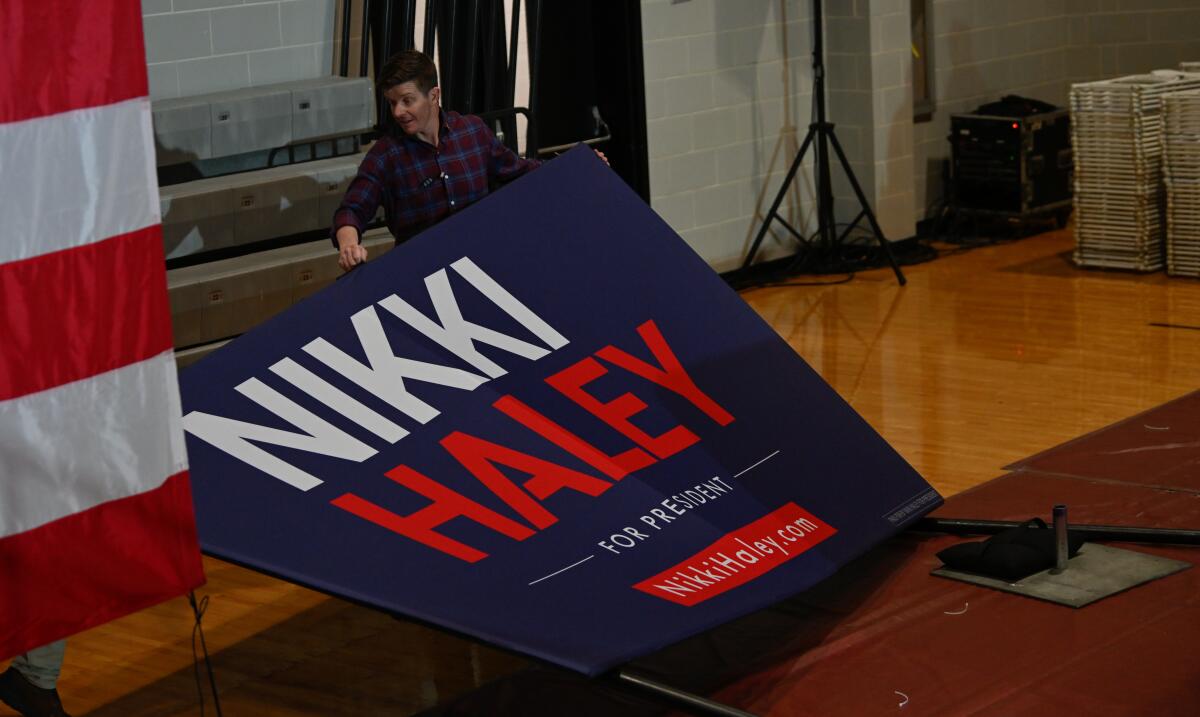 A man holding a floppy banner that says "Nikki Haley"