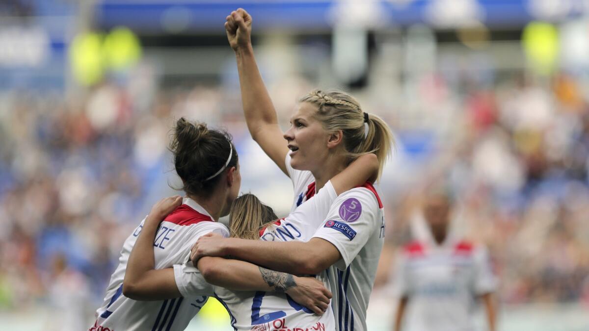 Lyon's Delphine Cascarino, center, celebrates with Ada Hegerberg, right, and Lucy Bronze after scoring against Chelsea during the Women's Champions League semifinal soccer match in Decines, France.