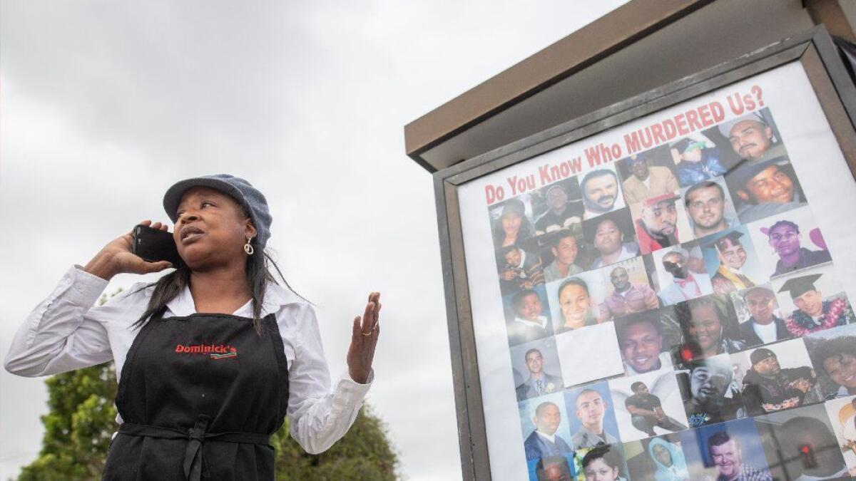 LaWanda Hawkins, whose son was killed in 1995, gives directions before unveiling the first bus shelter in a campaign featuring photographs of victims of unsolved homicides.