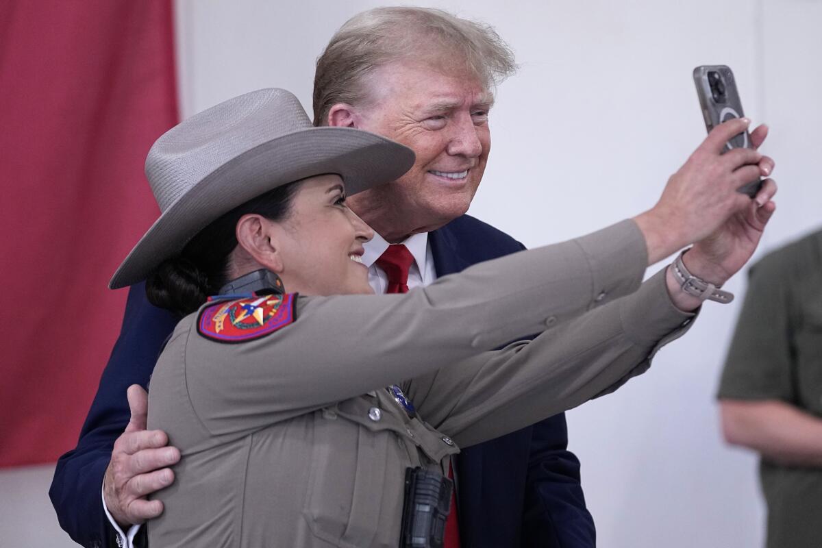 Donald Trump poses for a photo with a Texas state trooper.