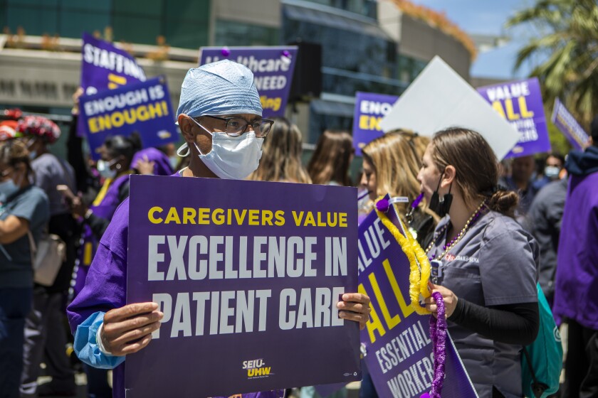 Healthcare workers hold signs during a strike.