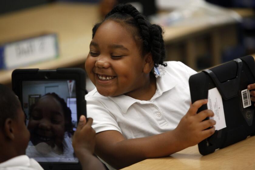 Tiannah Dizadare smiles as she works with classmate Avery Sheppard as they explore their new LAUSD-provided iPads.