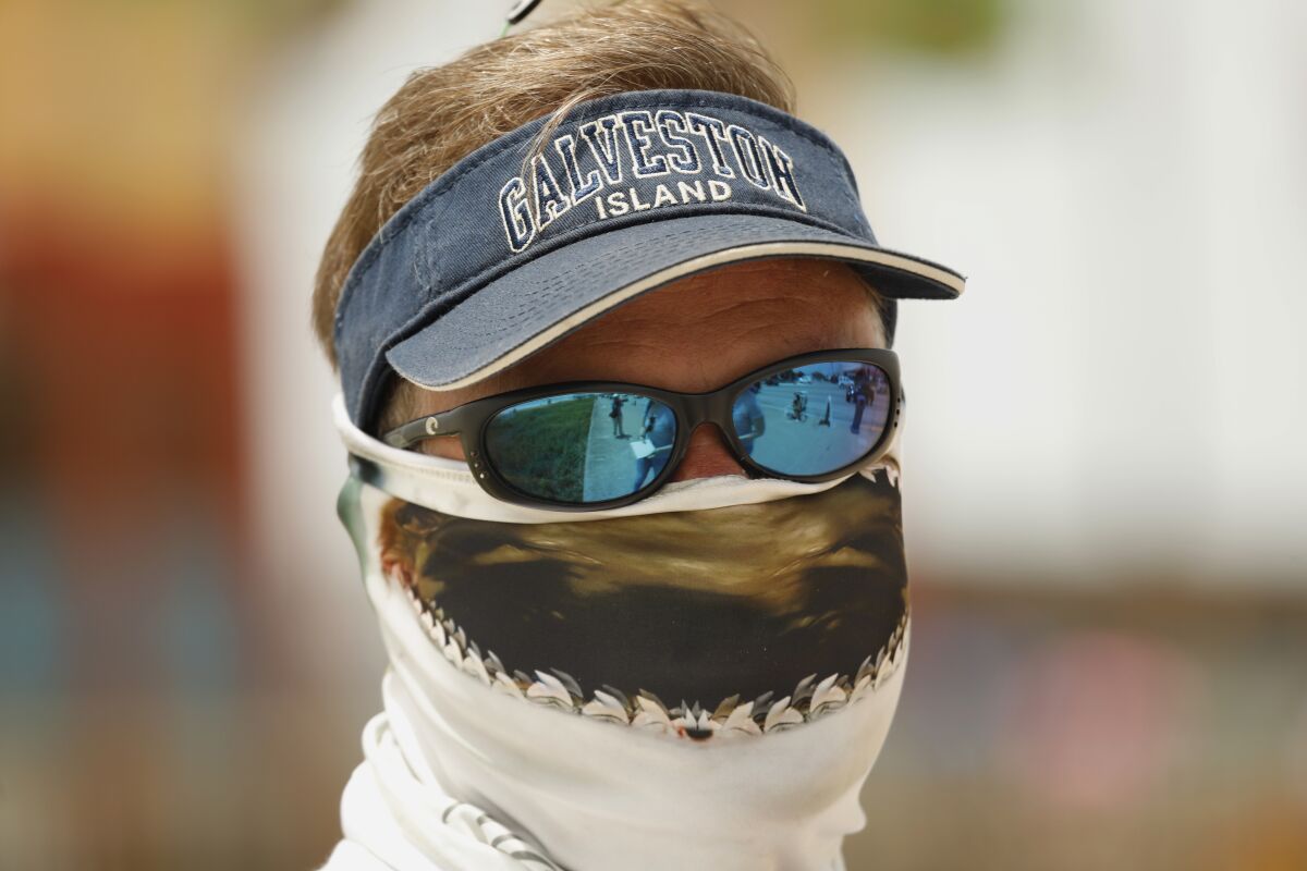 Raymond Smith, owner of Duck Tours on Galveston Beach, wears a shark scarf on his face.