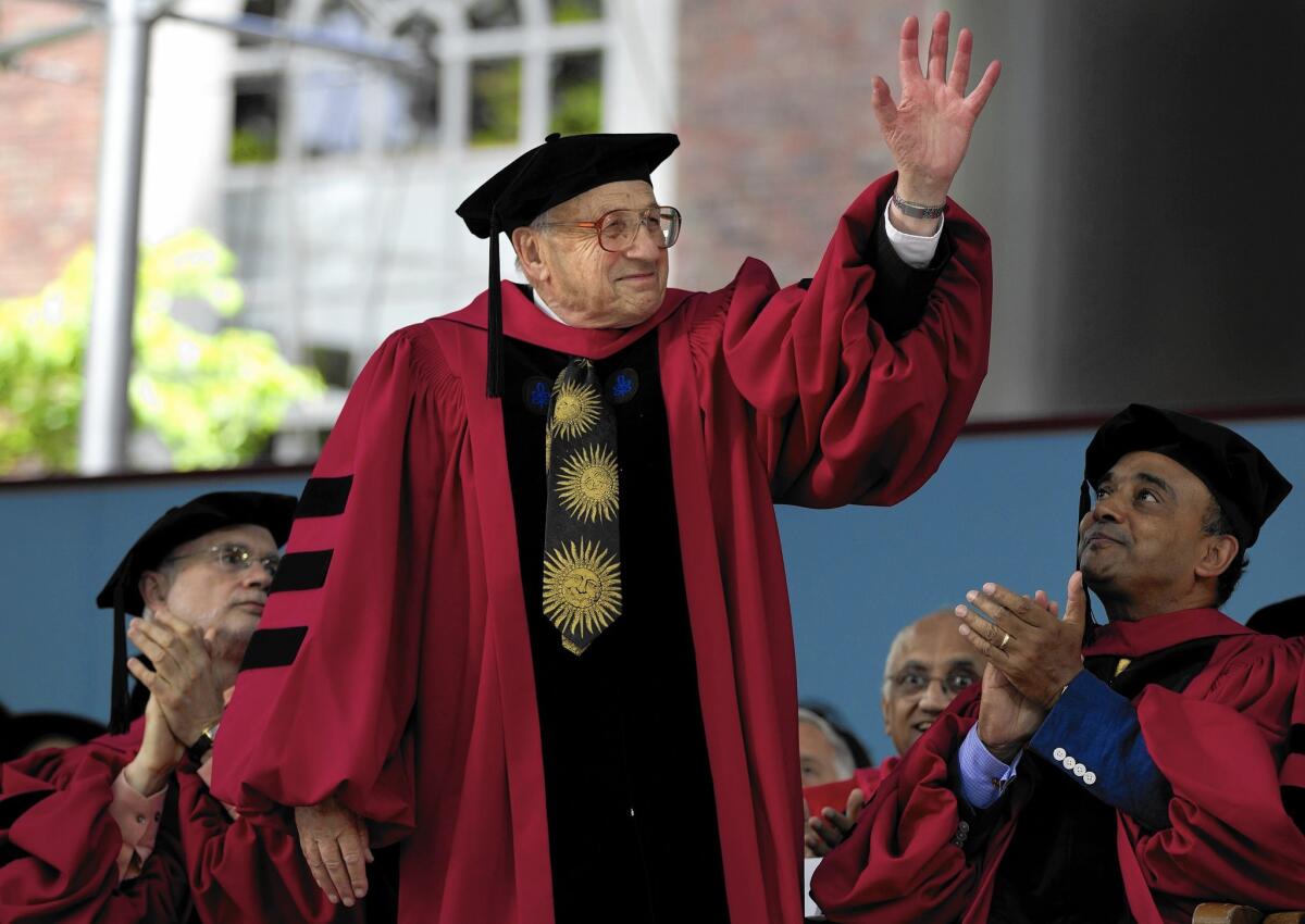 UC Santa Barbara physicist Walter Kohn, who shared the 1998 Nobel Prize in chemistry, waves to the audience during commencement exercises at Harvard in 2012.