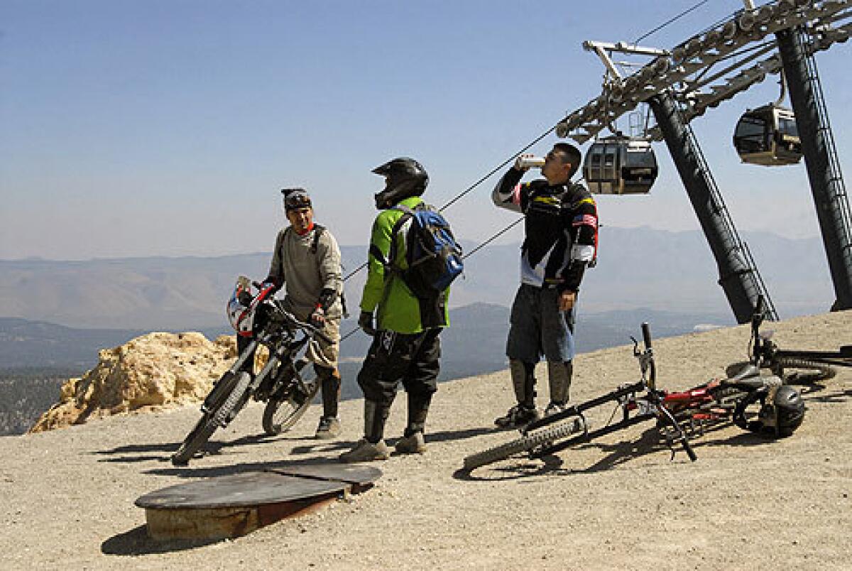 Gustav Betanvourth, left, and friends take a break before heading down a bike trail at Mammoth Mountain.