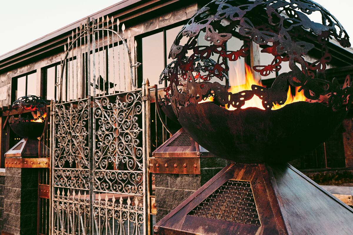 Mariposa restaurant exterior features a sculpture emitting fire. 