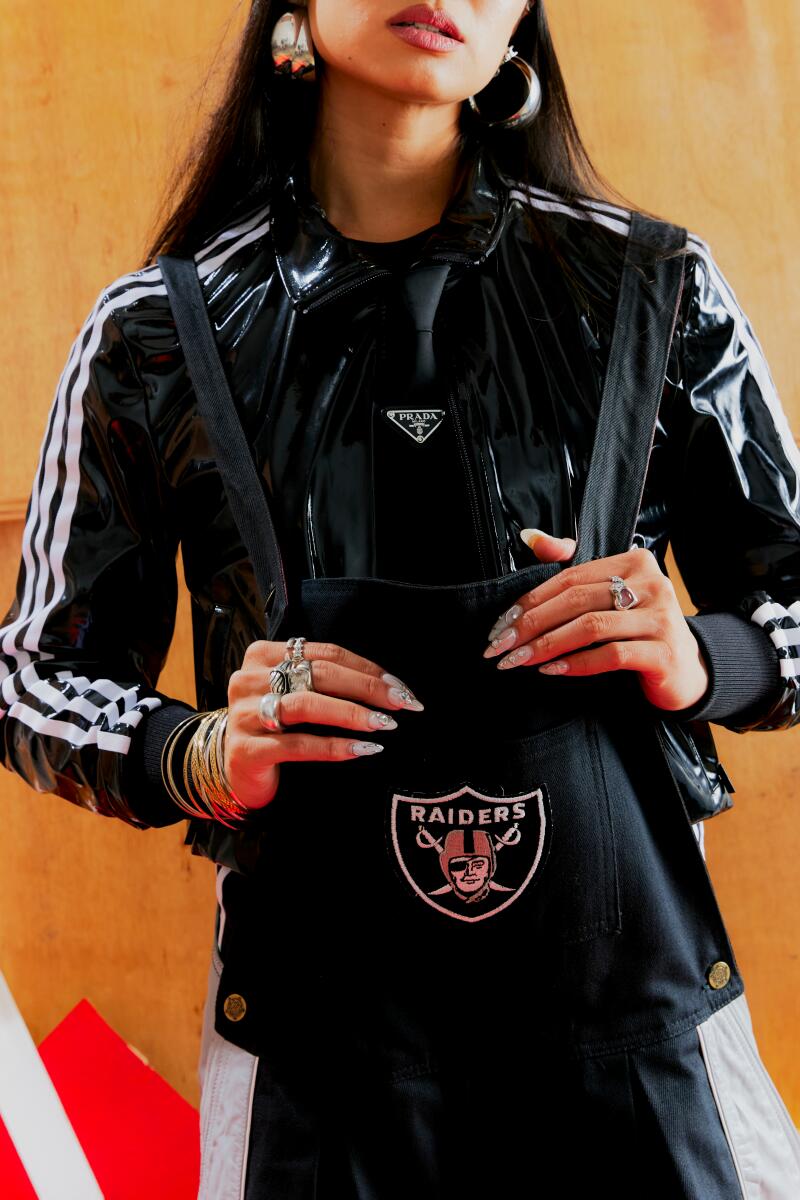 Close-up of Ann-Marie Hoang wearing a black jacket and holding a Raiders bag.