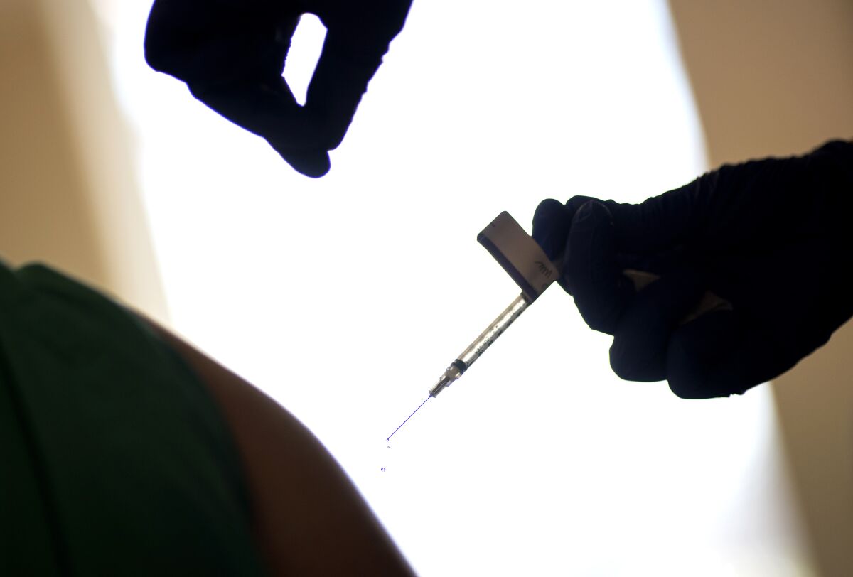 A droplet falls from a syringe after a healthcare worker was injected with the Pfizer-BioNTech COVID-19 vaccine