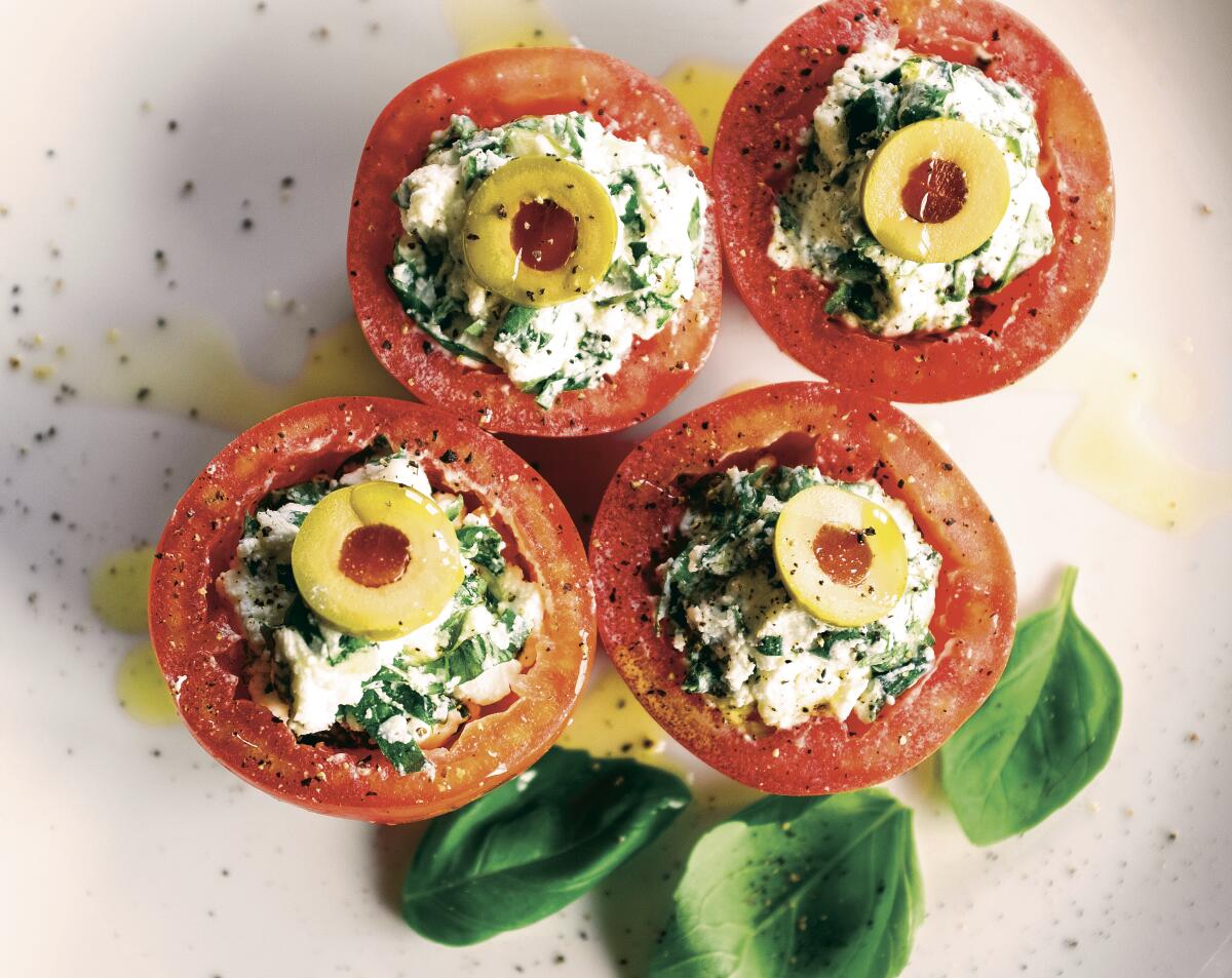 Tomatoes filled with whipped cheese and herbs topped by slices of green olives