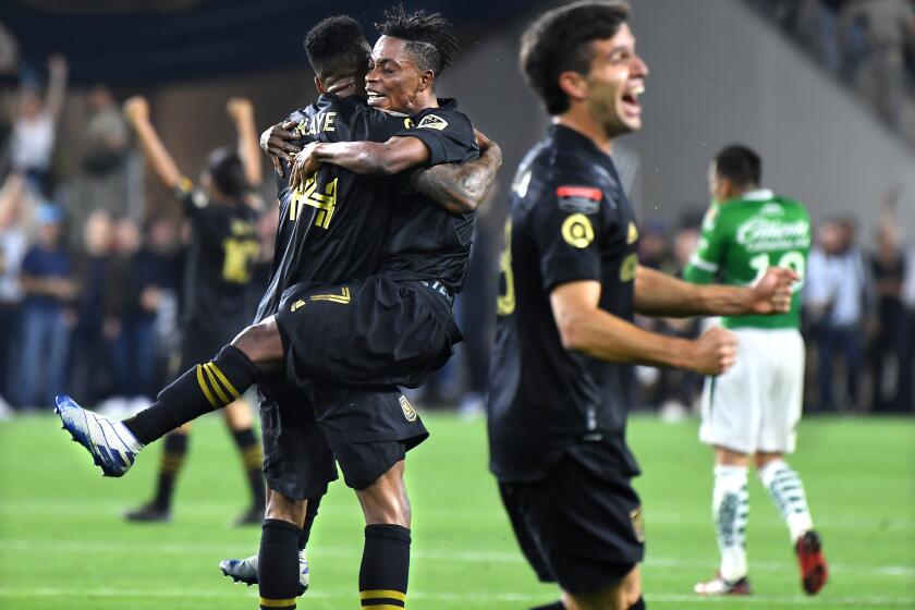 LOS ANGELES, CALIFORNIA FEBUARY 27, 2020-LAFC's Latif Blessing (7) jumps into the arms of teammate Mark-Anthony Kaye as they celebrate their win over Leon during the CCONCACAF Championship League match at Banc of California Thursday. (Wally Skalij/Los Angeles Times)