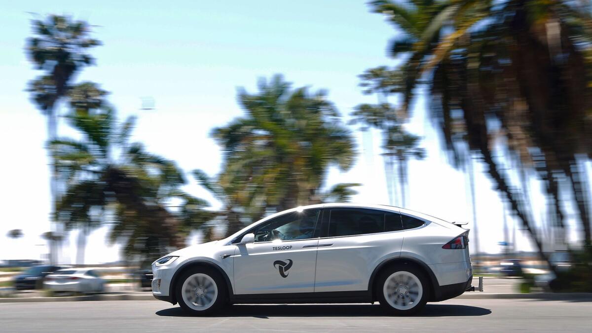 A Tesloop car drives near Mission Bay. The car riding offers service between cities such as San Diego, Los Angeles, Orange County and Palm Springs. The service uses Teslas with amenities and includes amenities such as free wifi, chargers, snacks and drinks.