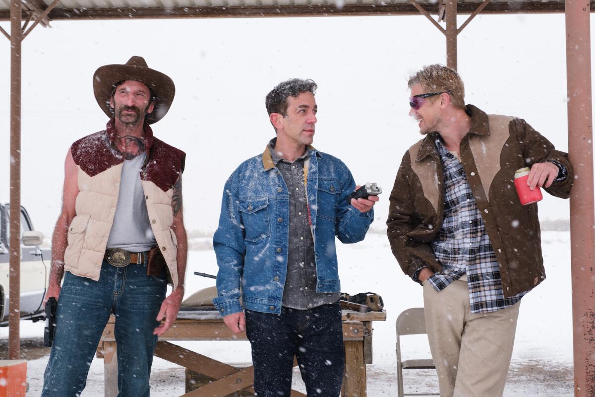 Three men in contemporary western attire amid snow flurries in the movie "Vengeance."