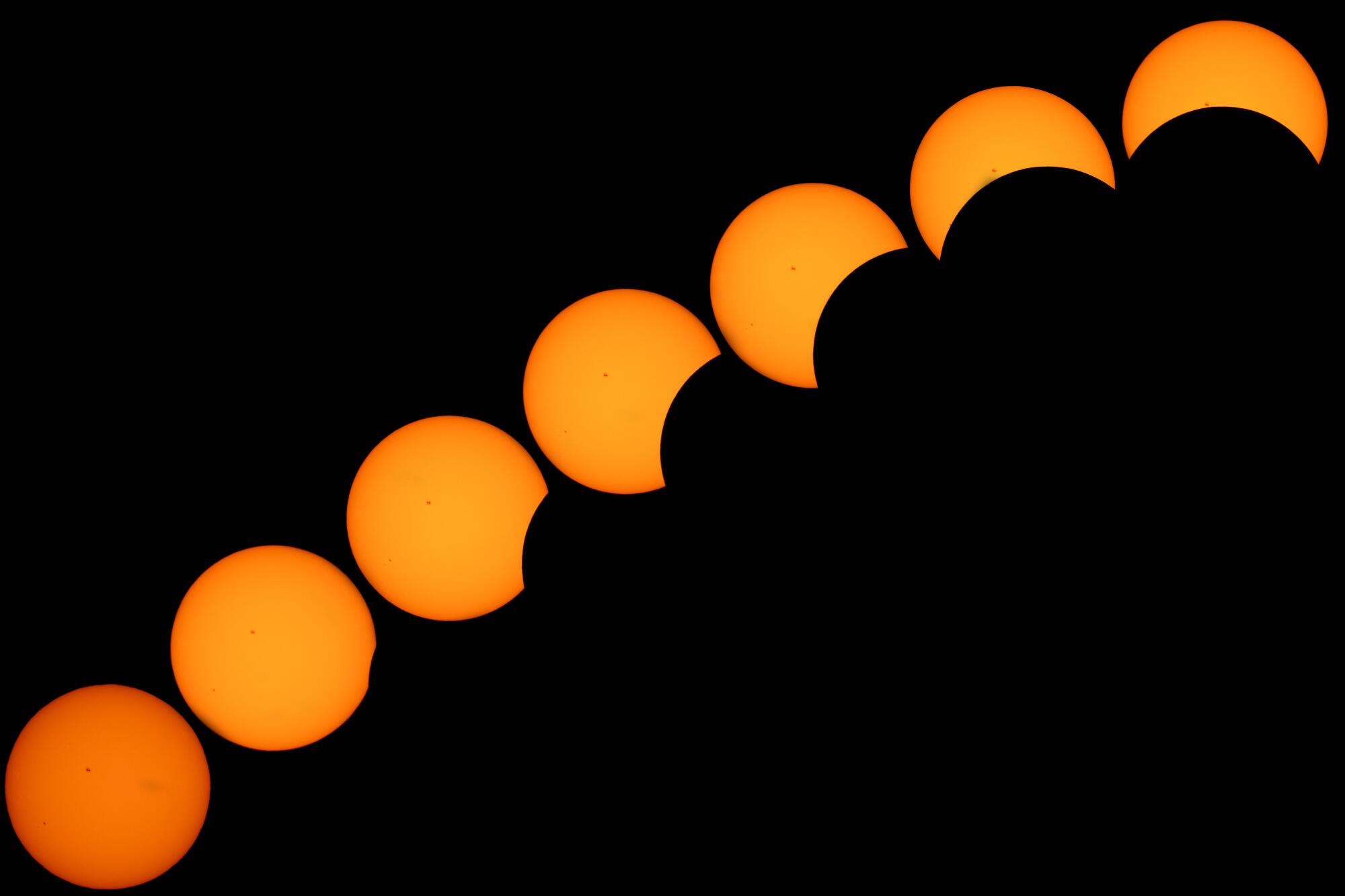 A photo composite of the sun as part of it increasingly becomes blocked by the moon against a black background.