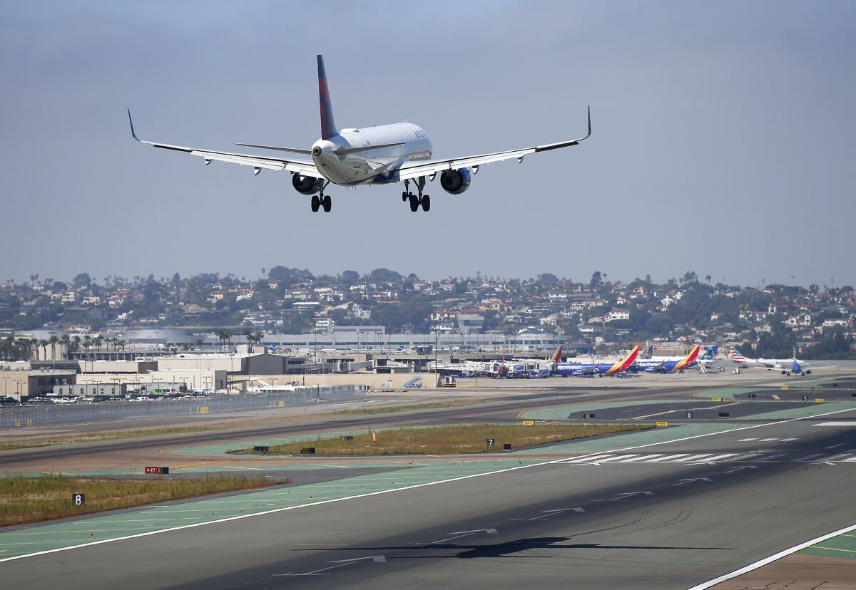 A Delta Airlines jet approaches San Diego International Airport for a landing on the runway.