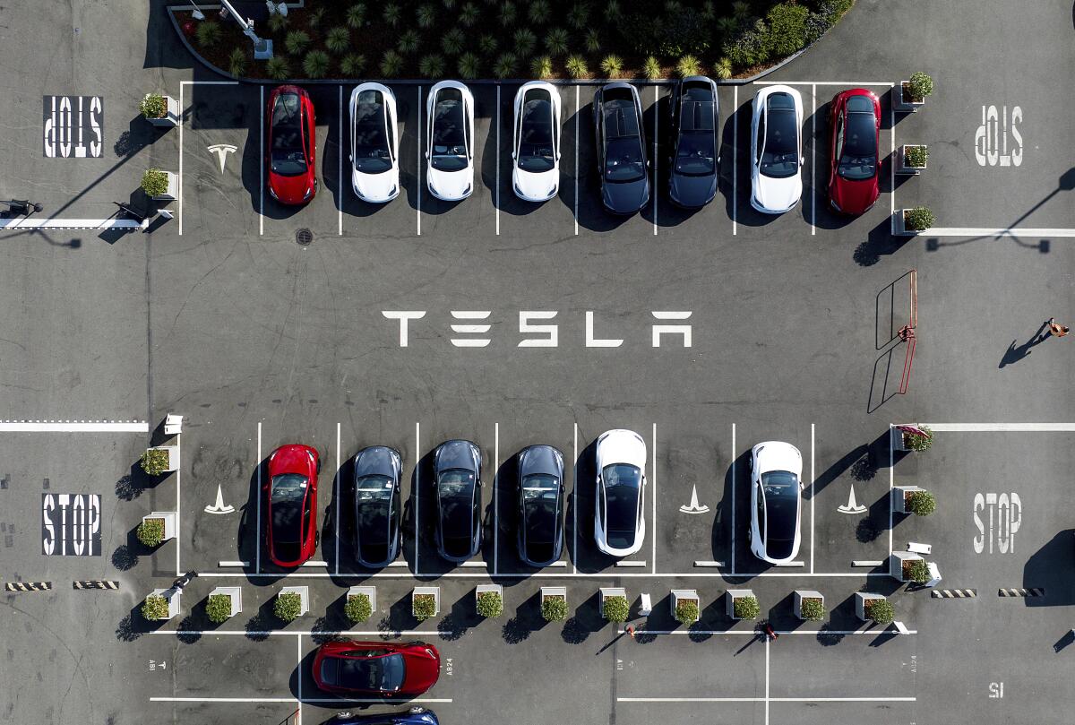 Tesla vehicles line a parking lot