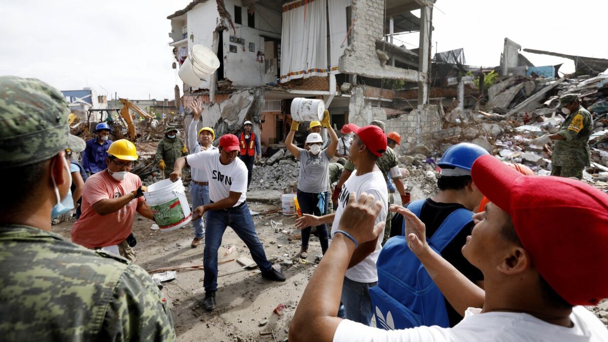 Volunteers and Mexican soldiers remove rubble in Jojutla on Sept. 23, 2017.