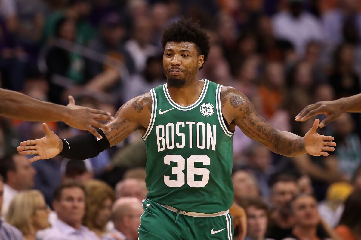 Celtics guard Marcus Smart gets high-fives from teammates during a break in play against the Suns on Nov. 18, 2019, in Phoenix.