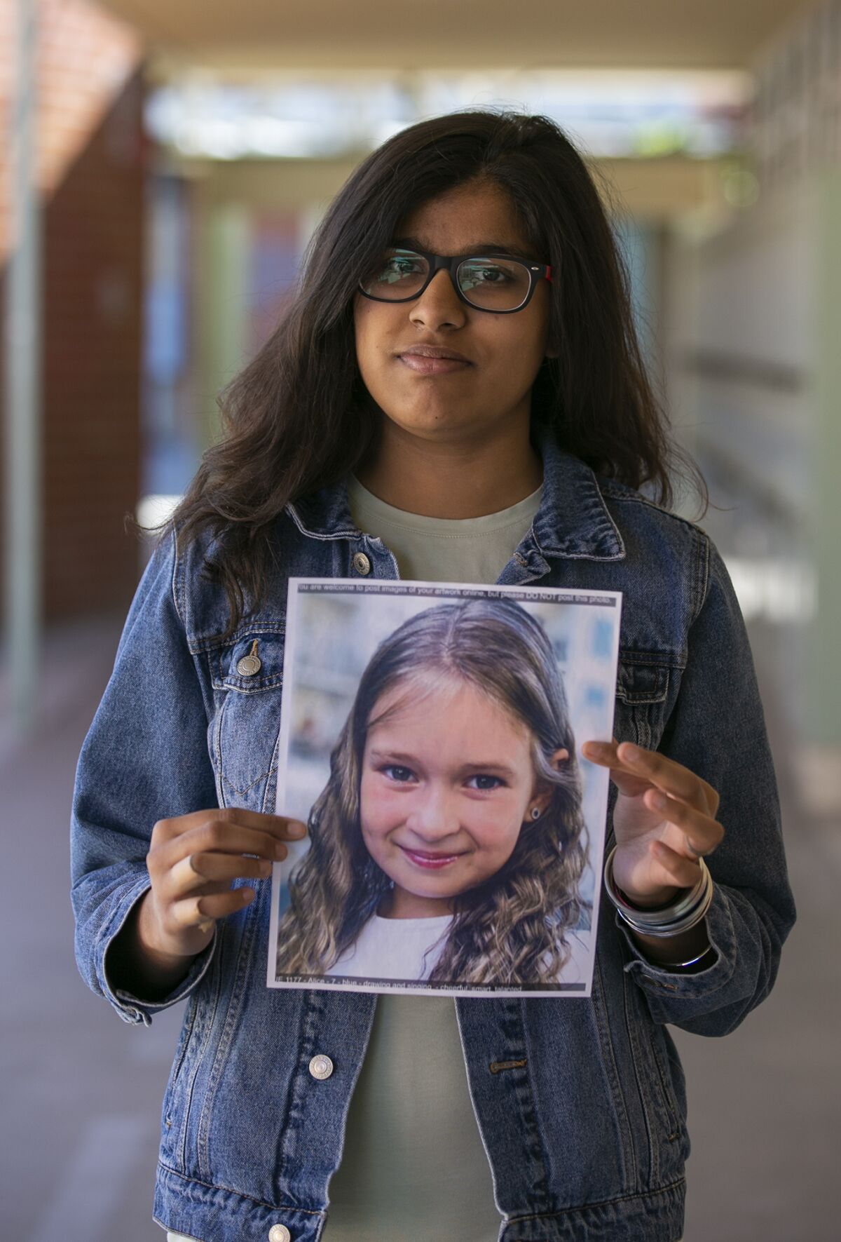Costa Mesa student Fnu Anu, 17, with a picture of the student she painted Alice.