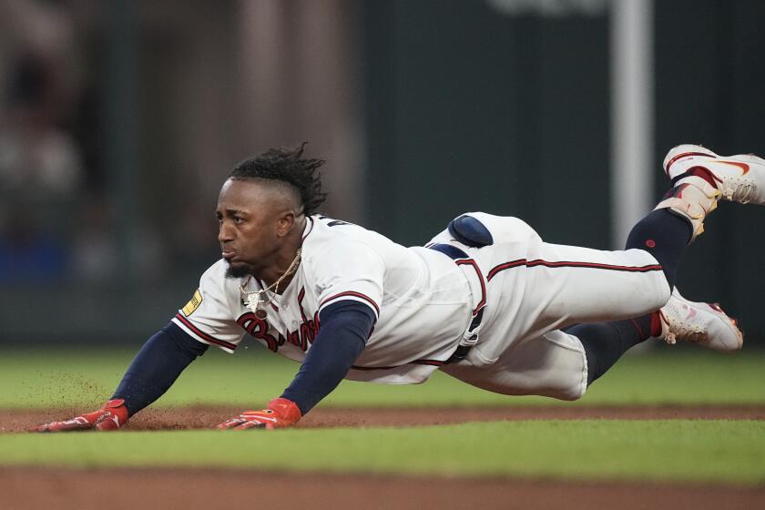 Atlanta Braves' Ozzie Albies dives into second base with a double in the first inning of a baseball game against the Chicago Cubs, Tuesday, Sept. 26, 2023, in Atlanta. (AP Photo/John Bazemore)