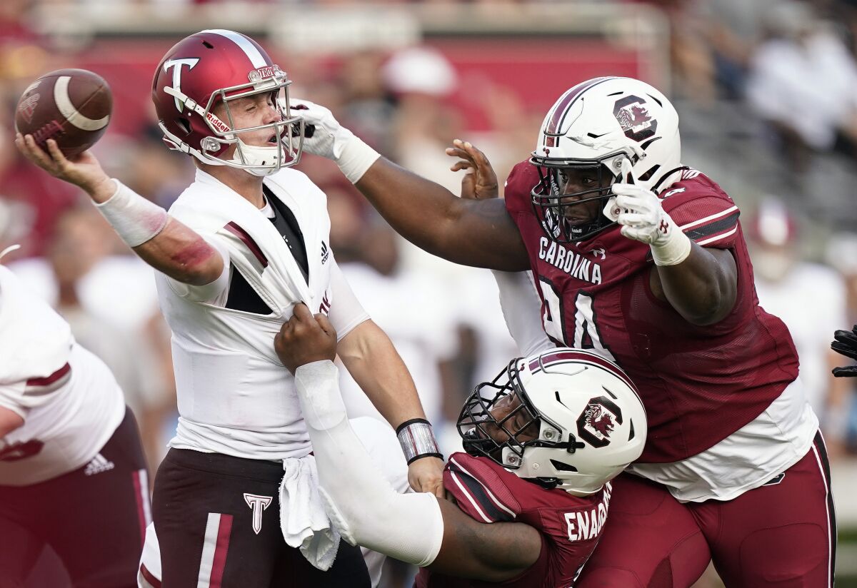 Troy quarterback Taylor Powell, left, is tackled by South Carolina defensive end Kingsley Enagbare, center, in the second half of an NCAA college football game Saturday, Oct. 2, 2021, in Columbia, S.C. (AP Photo/Brynn Anderson)