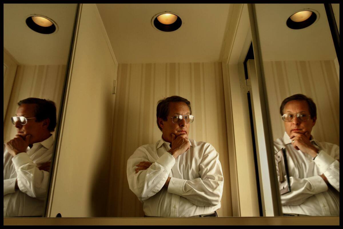 William Friedkin stands in front of a trifold mirror